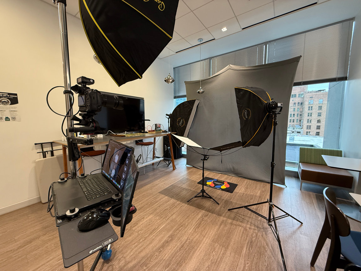 Photography studio with cameras, softbox lights, laptop, and backdrop setup