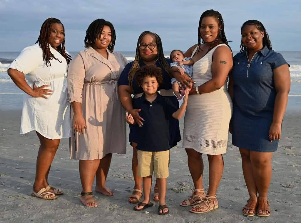 Group of women posing for a family portrait on the beach