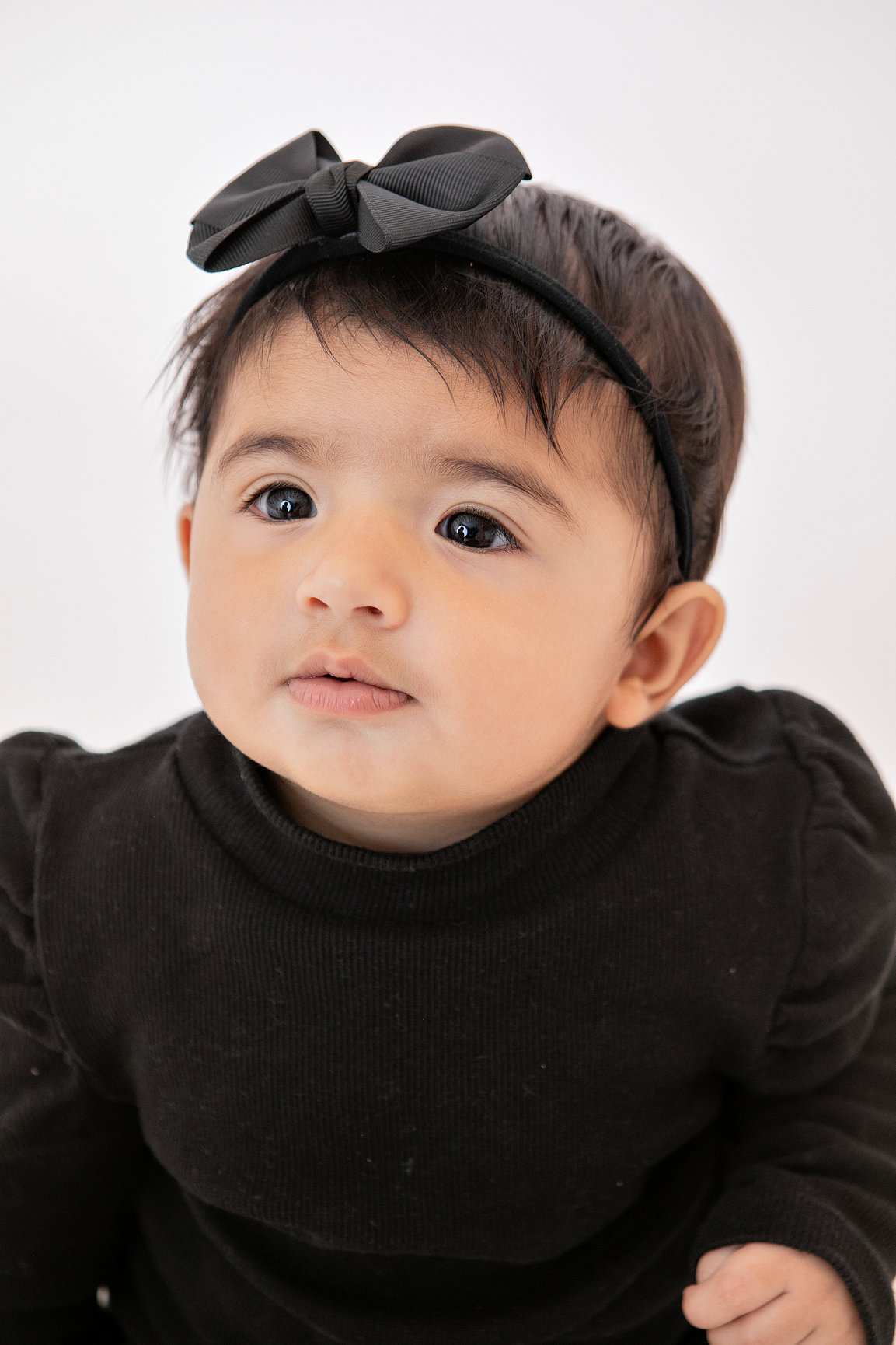 Baby in a black outfit looking to the side