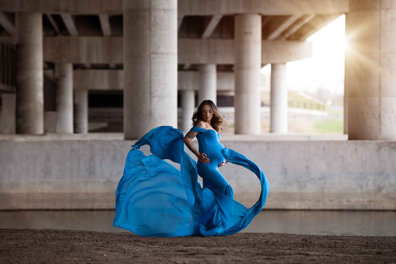 maternity session with wind blowing a blue dress
