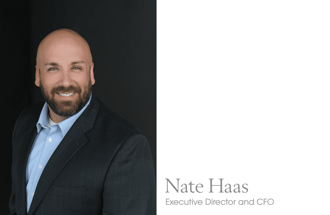 Nate, an executive director and CFO, poses in a business suit for a professional photo at Kliks Photography.