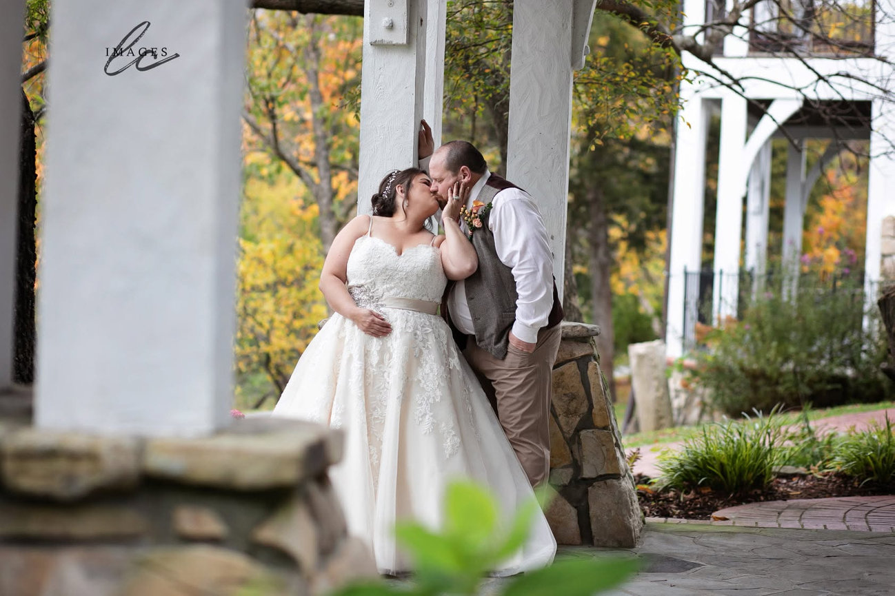 Bride and groom embracing outside near a house porch