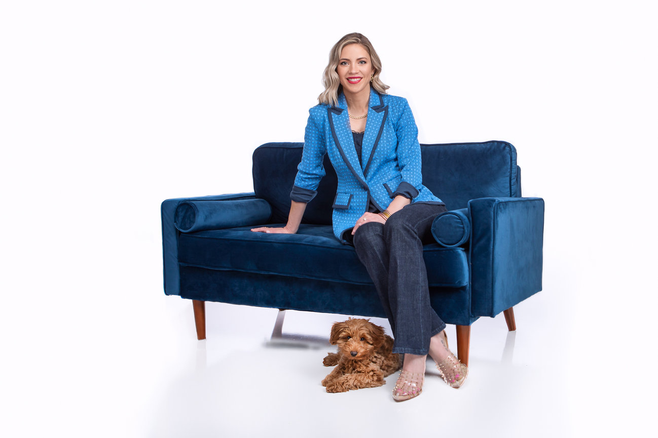 Client posing with her mini golden doodle sitting on a couch.