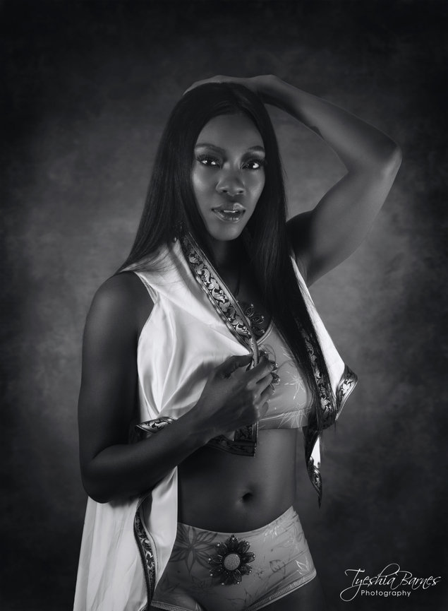 Studio fashion black and white portrait of woman in elegant swimwear with dramatic lighting.