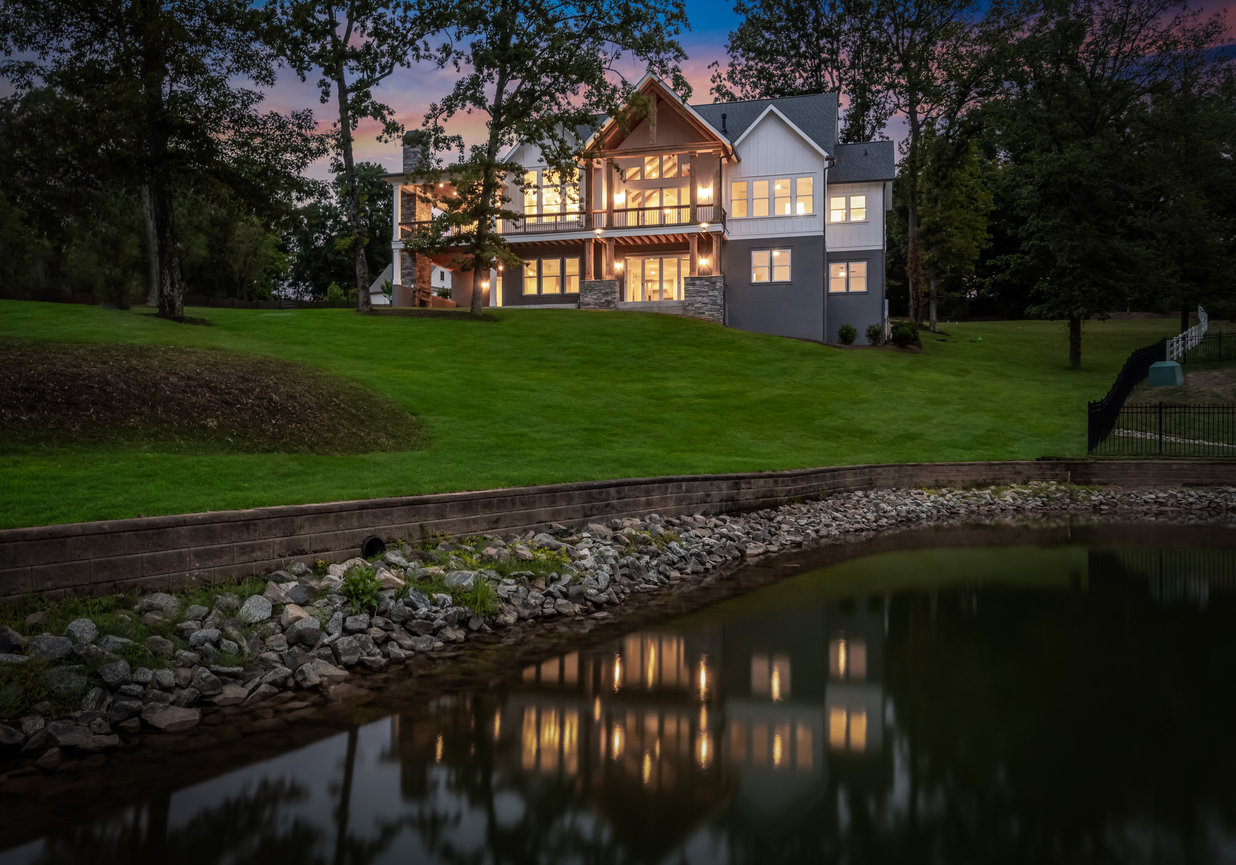 Luxury house on a grassy hill beside a pond at sunset, Denver NC