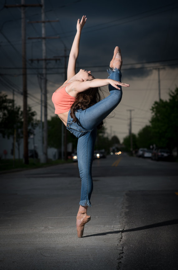 Teenage girl dancer in jeans and a coral tank on pointe for senior pictures in Dublin OH.