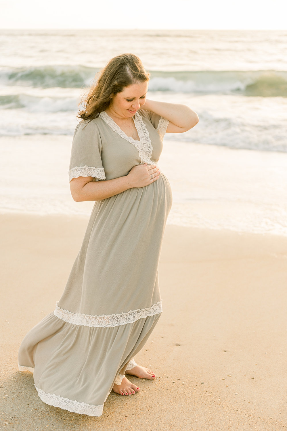 happy pregnant mom to be smiling down at her bump, Saint Augustine maternity photography