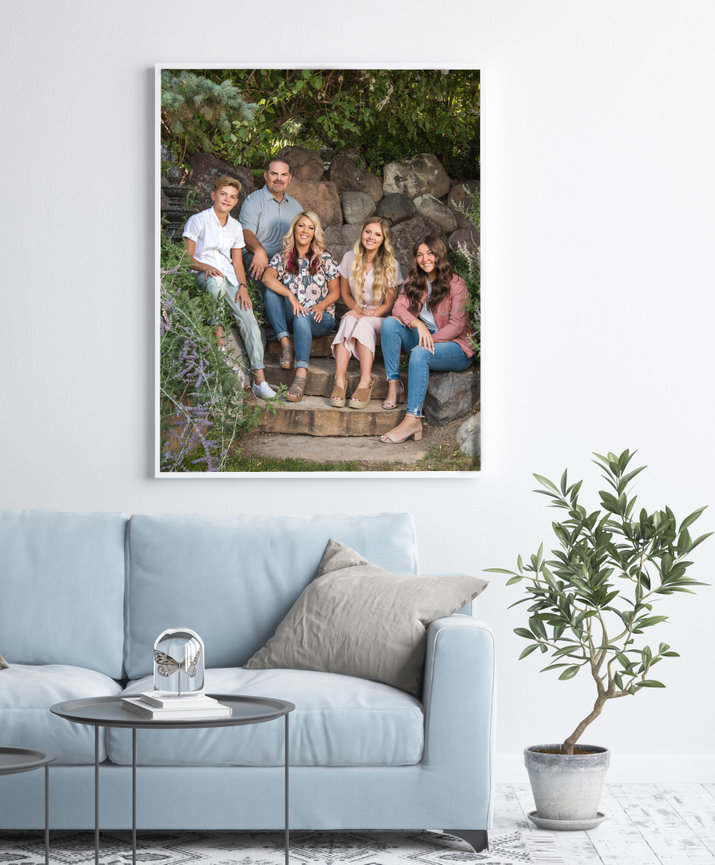 Blue couch with a large portrait hanging above it.